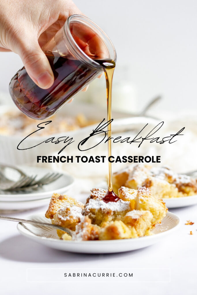 A hand pouring maple syrup over a plate of the French toast casserole.